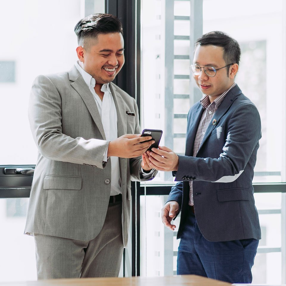 Dos consultores revisando información en un teléfono